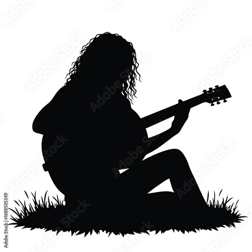 Woman playing acoustic guitar silhouette sitting in grass