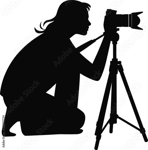 Silhouette of female photographer kneeling, taking pictures with DSLR camera on tripod, professional photography, isolated black figure
