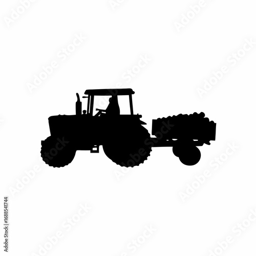 Silhouette of a tractor harvesting grapes in a vineyard