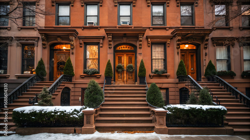 Historic brownstone townhouse entrance with snow and christmas wreaths