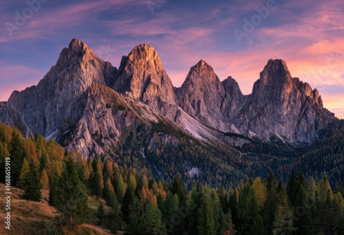 Mountain peaks bathed in vibrant sunset hues.  Forests of conifers and deciduous trees at base