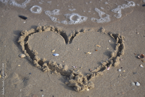 Heart drawn on the sand at sea