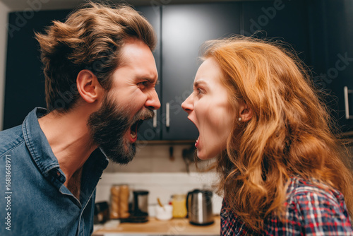 couple is quarreling in home. Angry husband and wife screaming in the kitchen. Family conflict, quarrel and disagreements. The couple is fighting. Domestic violence and abusive relationships