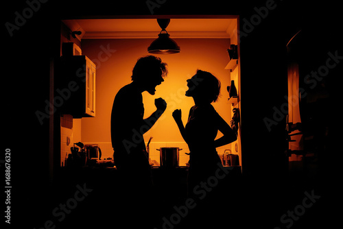 couple is quarreling in home. Silhouette of angry aggressive husband and wife screaming in the kitchen. Family conflict and quarrel. Couple is fighting. Domestic violence and abusive relationships