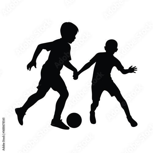 Silhouette of two young boys playing football