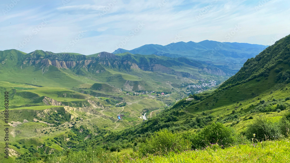 Obraz premium Trekking in the mountains of Azerbaijan. View from the height of the green slopes and mountain ranges. Beautiful green mountain valley