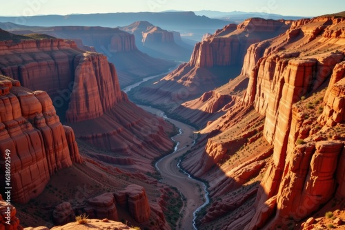 Wallpaper Mural vast canyon gorge shaped by flowing river erosion, immense geological formations glowing under golden sunlight Torontodigital.ca