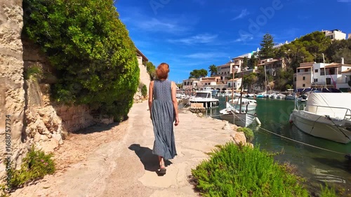 Woman in summer dress walks in Cala Figuera fishing village Mallorca Spain