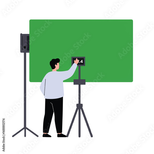 A filmmaker or videographer sets up a clapperboard in a studio with a large green screen background.