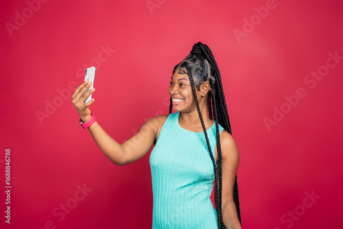 beautiful young african lady excited and rejoices while looking at her phone