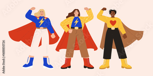 Three diverse women dressed as superheroes strike a powerful pose demonstrating strength and unity