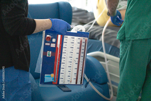 Bild auf Leinwand Nurse holding chest drainage system with patient in background in hospital room