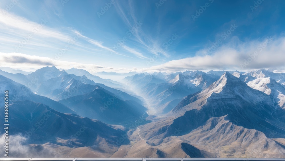Fototapeta premium Mountains and sky from above, showcasing rugged terrain and cloud formations.