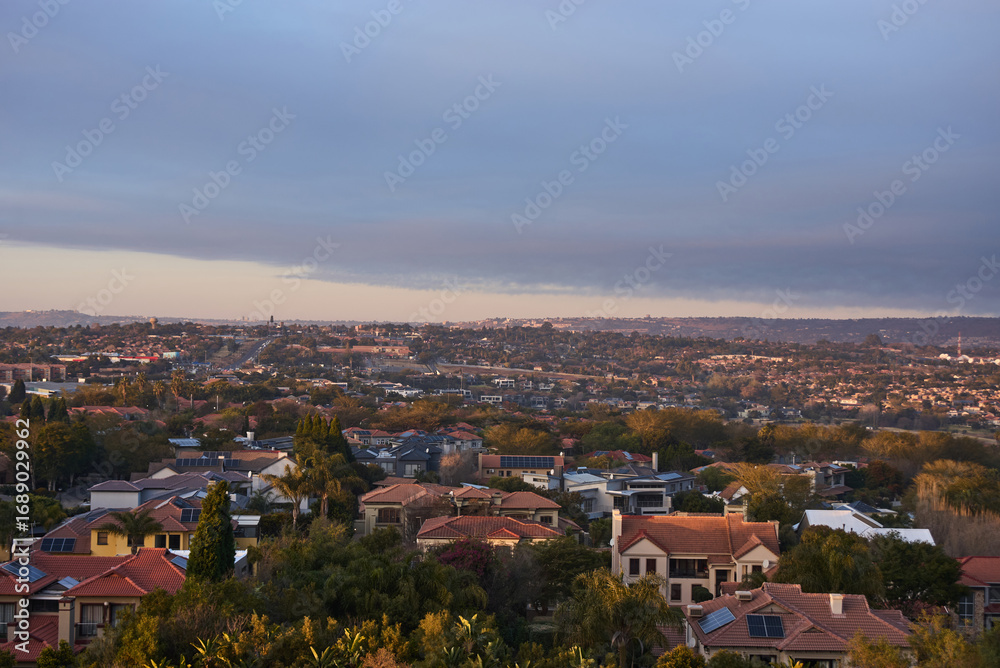 Fototapeta premium Aerial view of Johannesburg city centre at sunrise, South Africa. The skyline is bathed in warm morning light with urban streets, and a vibrant city atmosphere representing modern Africa.