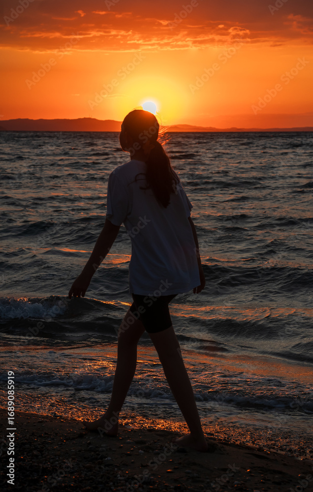 Fototapeta premium woman on the beach at sunset