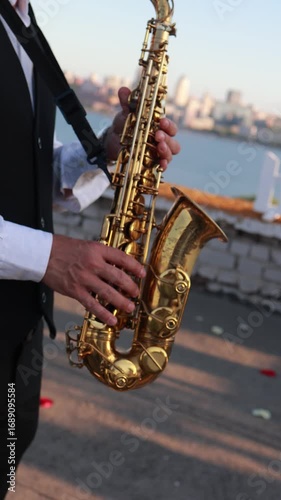 Musician playing saxophone outdoors at sunset in vertical video