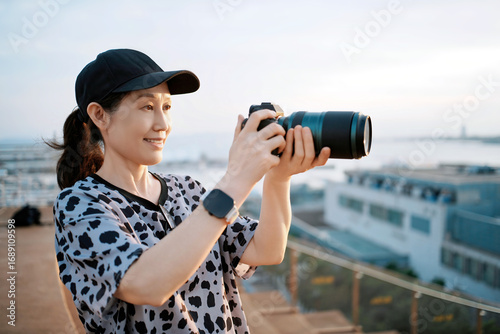 Woman with camera taking photo outdoors during daytime