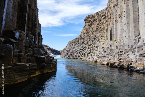 Принти на полотні Marvel at the striking basalt columns rising from crystal-clear waters in Studlagil Canyon, Iceland