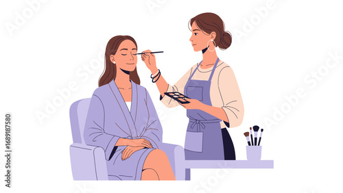 Professional makeup artist applying eyeshadow to a woman sitting in a chair wearing a robe