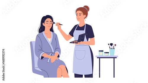 Professional makeup artist applying cosmetics to a smiling woman in a spa robe for a glamorous look