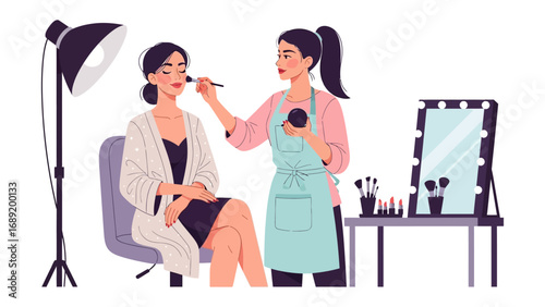 Professional makeup artist applying cosmetics to a model in a studio setting with lighting and mirrors