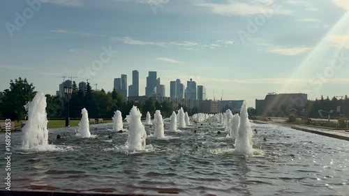 Wallpaper Mural Fountains Dance Joyfully Against the Skyline of a Bustling City in Warm Sunlight Torontodigital.ca