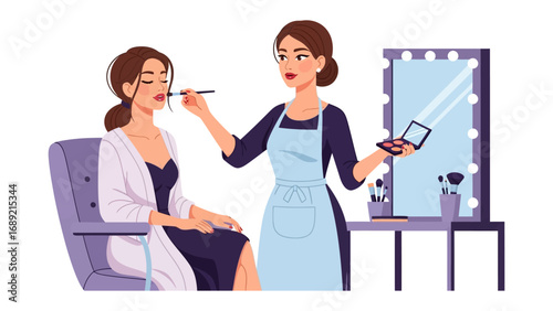 Professional makeup artist applying cosmetics to a client in a studio setting with a lighted mirror