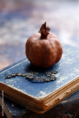 Silver Bracelet with Israeli symbols in the form of Magen David and dried pomegranate on old, tattered books of the Torah