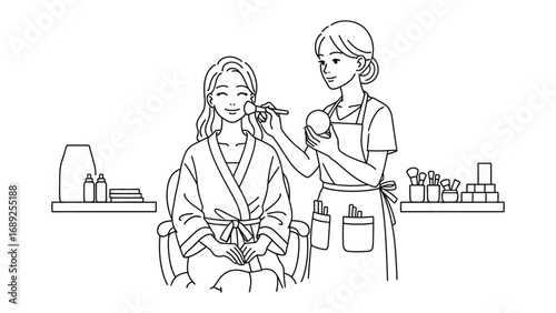 A skilled makeup artist carefully applies cosmetics to a young woman wearing a robe in a well lit beauty salon