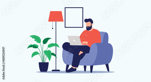 Man working on laptop while sitting on sofa in cozy room with plant lamp and picture