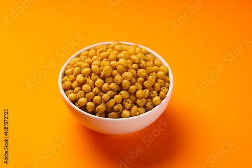 Indian snacks called spicy bundi or boondi isolated on orange background 