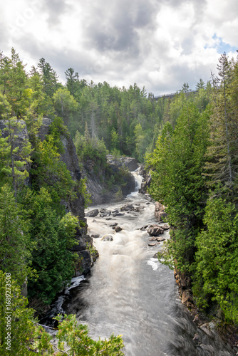 The Mississagi River flows gracefully through lush forests at Aubrey Falls, offering a breathtaking glimpse of Ontario's natural beauty.