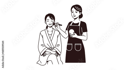Skilled makeup artist applying cosmetic foundation to a seated woman in traditional japanese attire