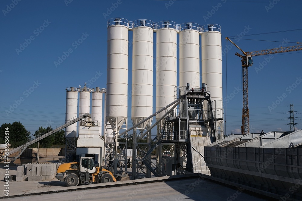 Obraz premium Scenery of concrete factory with white silos for production of concrete 