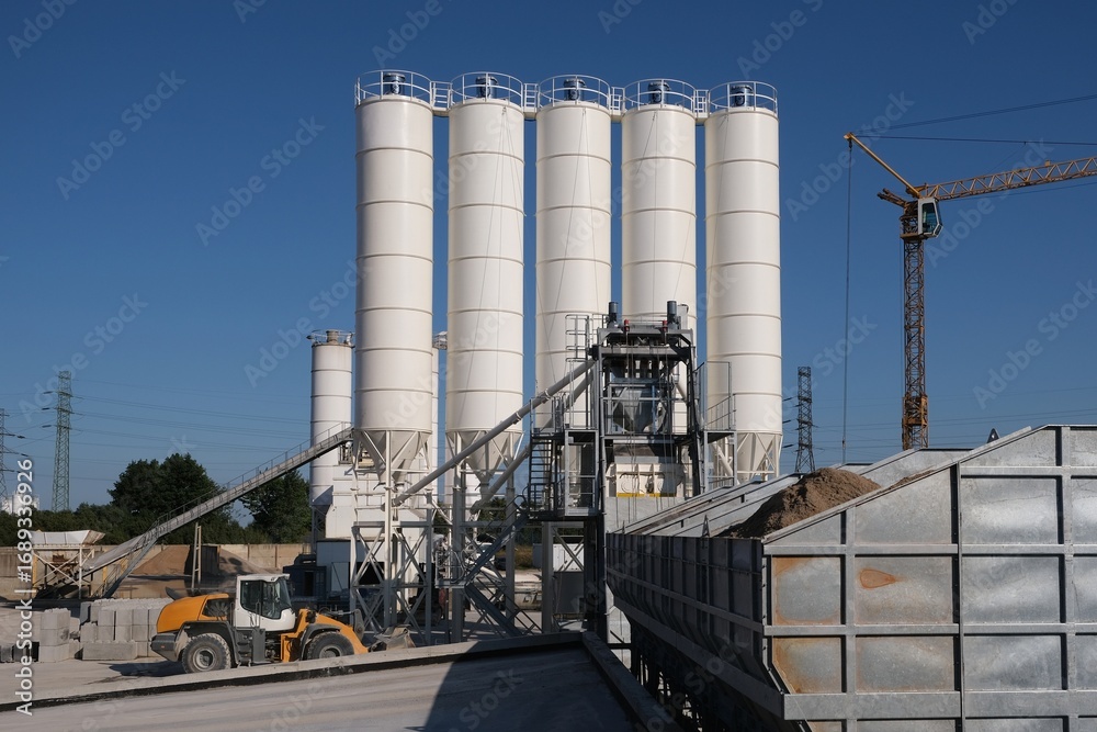 Obraz premium Scenery of concrete factory with white silos for production of concrete 