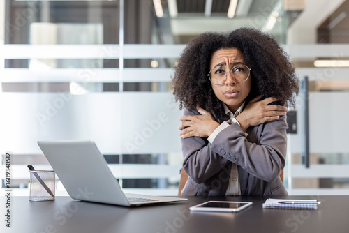Obraz na płótnie An African American young businesswoman sits at a desk in the office and is free