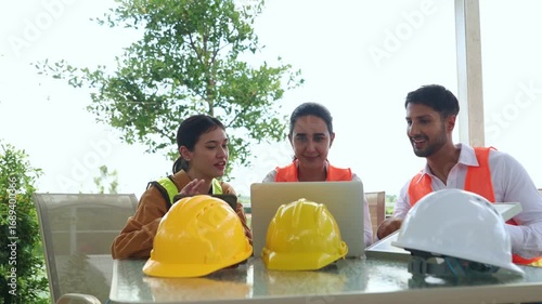 Indoor meeting male and female engineers discusses plans for a wind turbine system inspection renewable energy and sustainability before fieldwork : Renewable energy concepts that rely on wind.
