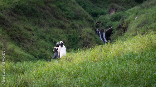 Happy tourist couple enjoying the view to small waterfalls.