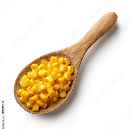 A wooden spoon filled with delicious, yellow corn kernels
