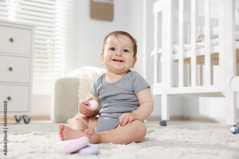 Cute little baby playing with toys in room