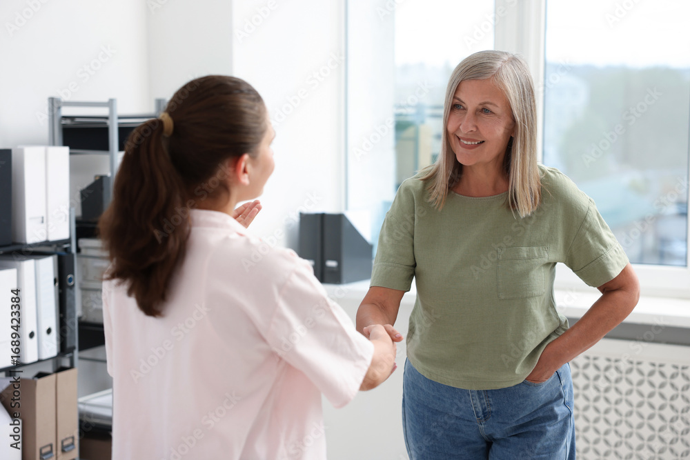 Obraz premium Cooperation and teamwork. Women shaking hands in office