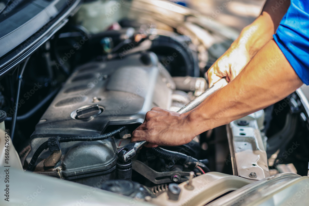 Fototapeta premium A man is working on a car engine
