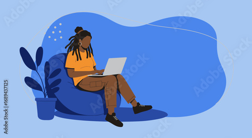 Relaxed woman with dreadlocks working remotely on laptop from a comfortable bean bag chair at home. Concept of freelance work, online learning, and flexible lifestyle.