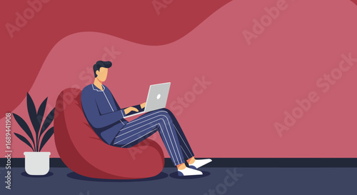 A man in comfortable pajamas works remotely on his laptop from a cozy bean bag chair at home, embodying modern work-life balance and digital productivity.