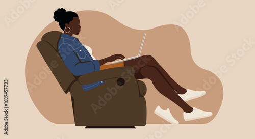 Relaxed Black woman works on a laptop in a comfortable recliner chair. Ideal for remote work, freelance, online learning, and home lifestyle concepts.