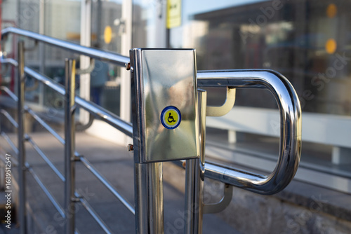 Accessible handrail system for individuals with limited mobility, equipped with easy to use button. Structure helps in facilitating access for wheelchair users and those requiring assistance