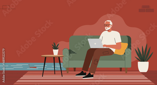 Senior man with glasses and a beard sitting comfortably on a green sofa, focused on working or browsing his laptop at home. Modern digital lifestyle and remote connectivity.