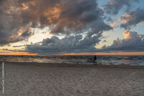 Cyclist at sunset by the sea.