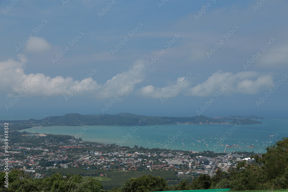 Fototapeta premium clouds over the city and blue sea