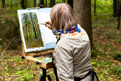 An artist paints nature in a park. 